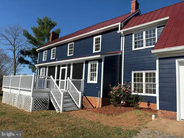 a view of a house with a yard and lawn chairs