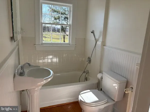 a white toilet sitting next to a bathroom sink and tub