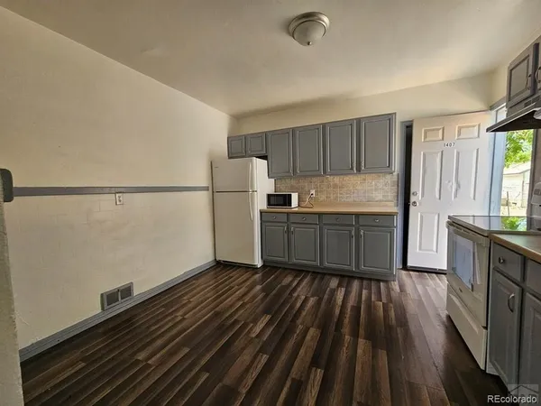 a kitchen with a sink a refrigerator freezer a stove and a window