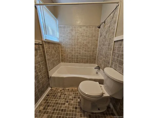a bathroom with a toilet a sink and bathtub