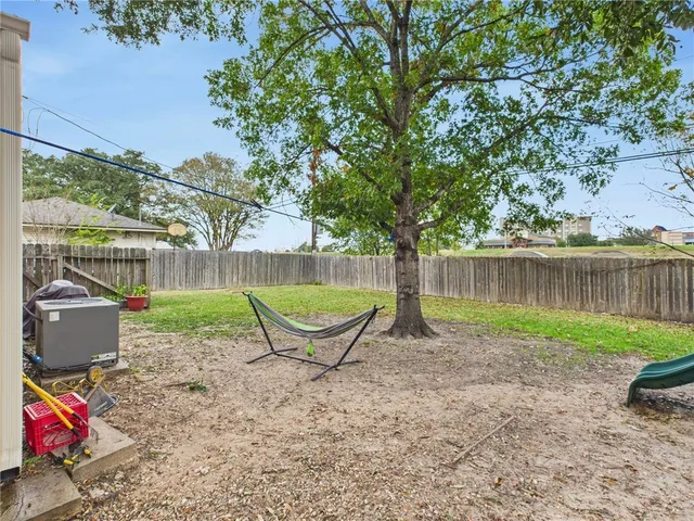 a view of a backyard with table and chairs potted plants and wooden fence