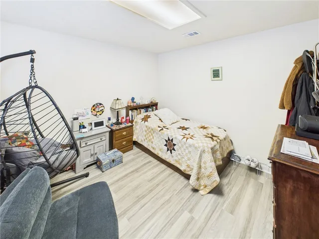 a bed sitting in a bedroom next to a window with tv and couch