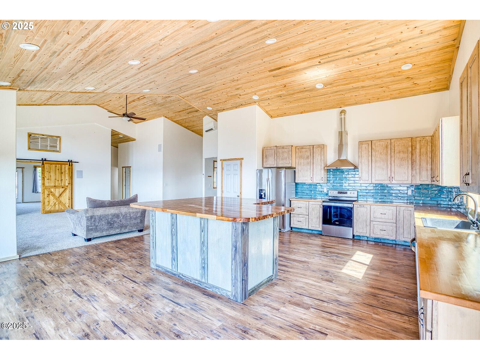 946 North Echo Mountain Road Otis, OR 97368 - Photo 15 of 48 a living room with couches and kitchen view with wooden floor