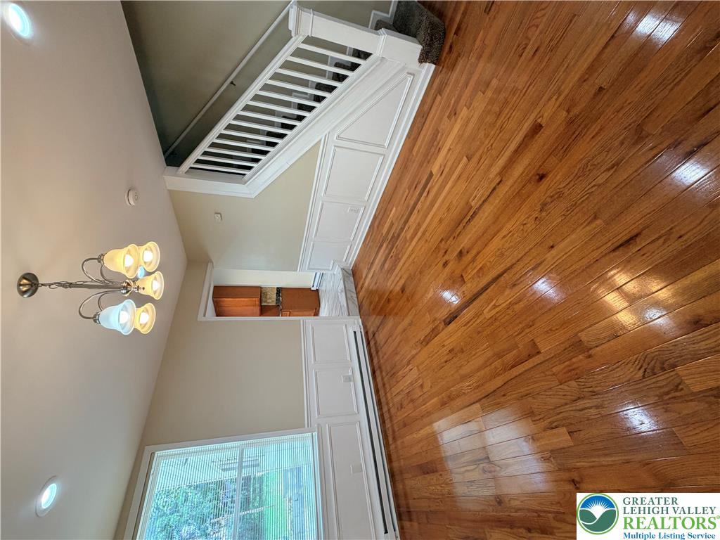 718 Ferry Street Easton, PA 18042 - Photo 5 of 37 Rich hardwood flooring extends across this spacious living area, complemented by a graceful chandelier.