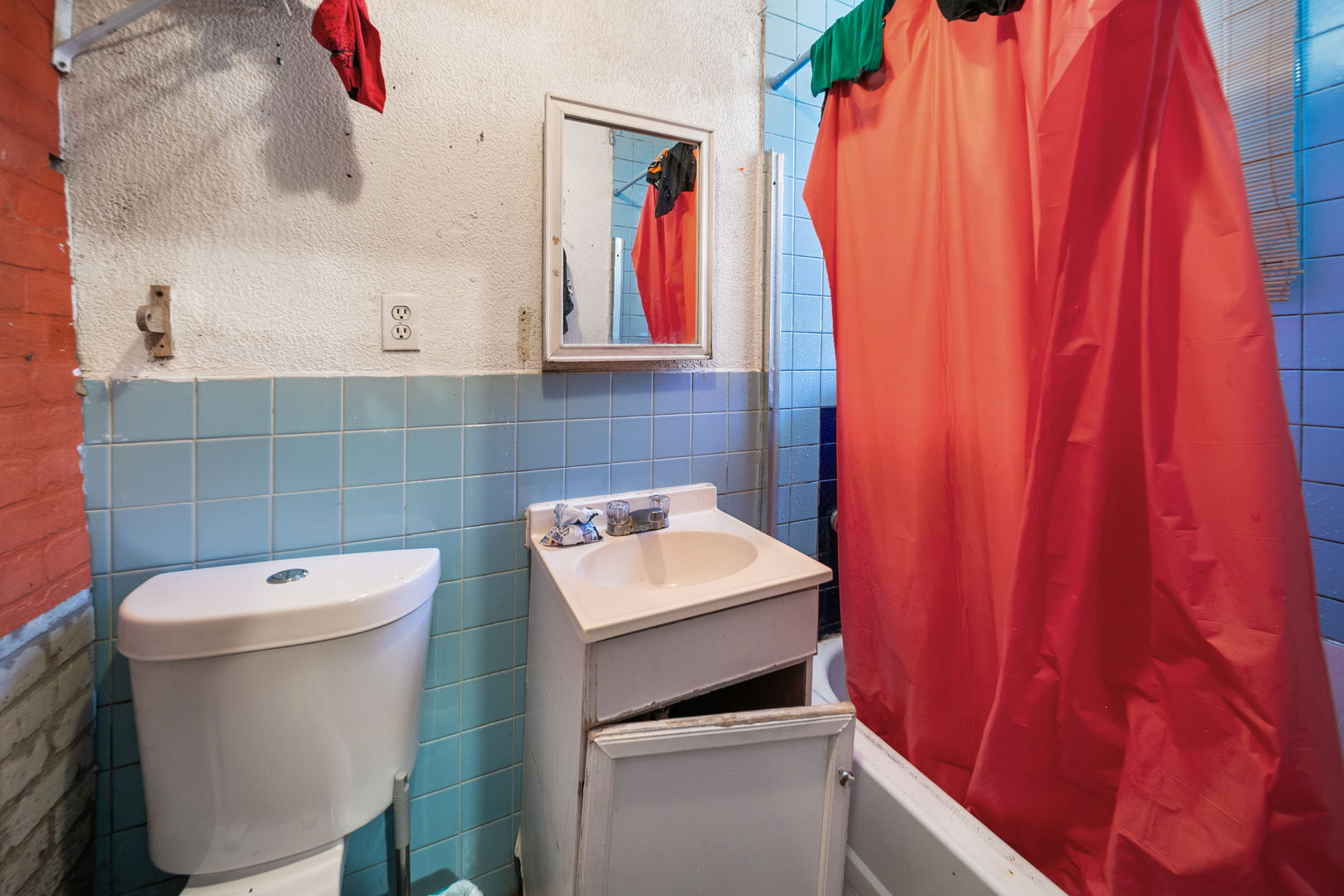 2522 South Christiana Avenue Chicago, IL 60623 - Photo 6 of 8 a bathroom with a toilet a sink and curtain