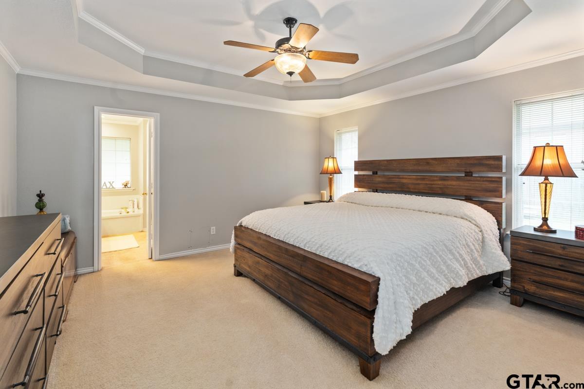 1113 Lonnie Drive Athens, TX 75751 - Photo 19 of 32 a spacious bedroom with a bed and a chandelier