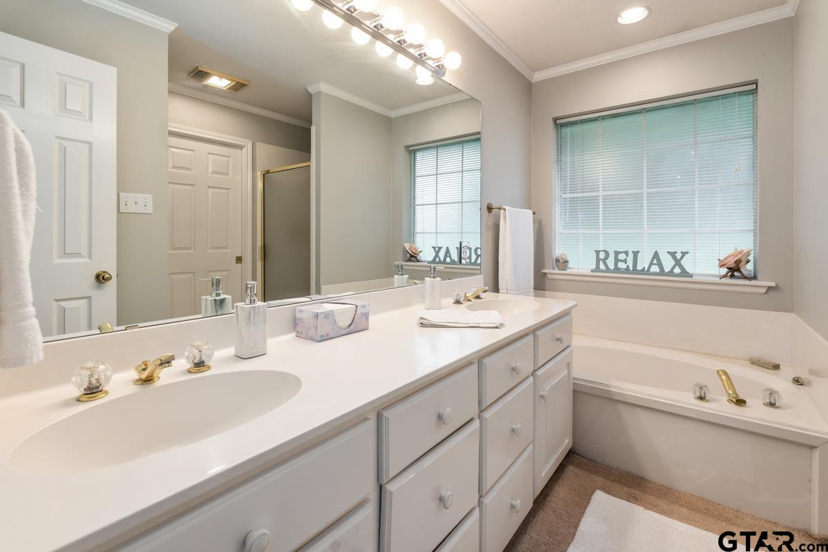 1113 Lonnie Drive Athens, TX 75751 - Photo 21 of 32 a bathroom with a tub a double vanity sink a mirror and a bathtub