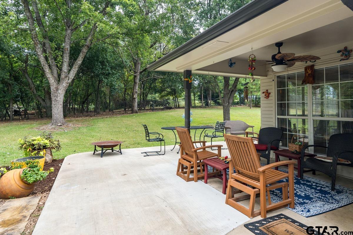 1113 Lonnie Drive Athens, TX 75751 - Photo 29 of 32 a view of a patio with table and chairs potted plants and a palm tree