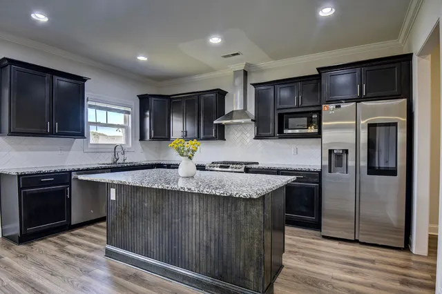 a kitchen with stainless steel appliances granite countertop a sink stove and refrigerator