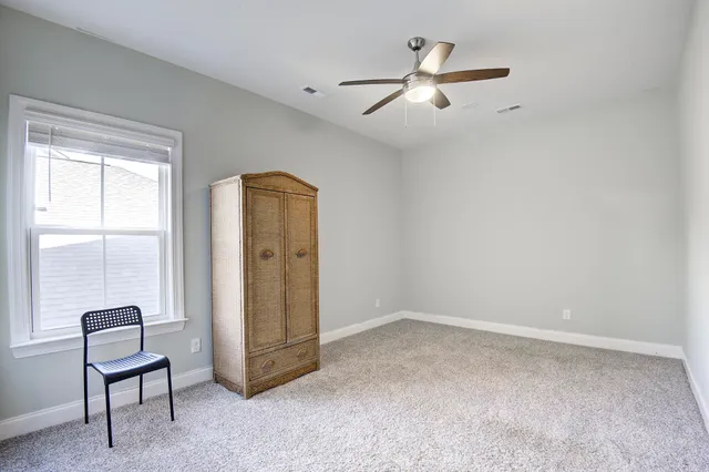 a view of a room with window a ceiling fan and wooden floor