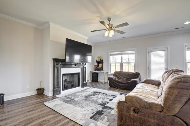 a living room with furniture a flat screen tv and a fireplace