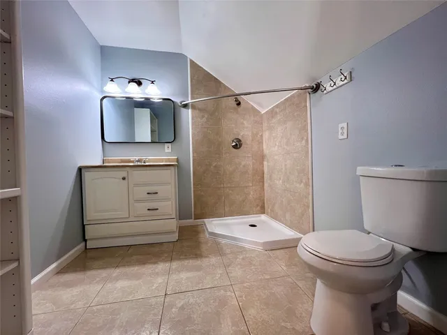 an empty room with chandelier fan and windows