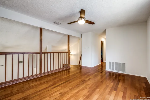 a view of an empty room with wooden floor