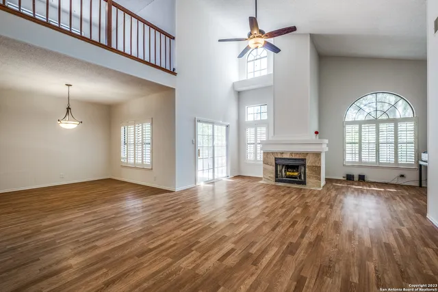 wooden floor fireplace and windows in an empty room