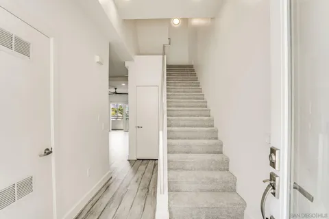 a view of a hallway with wooden floor and staircase