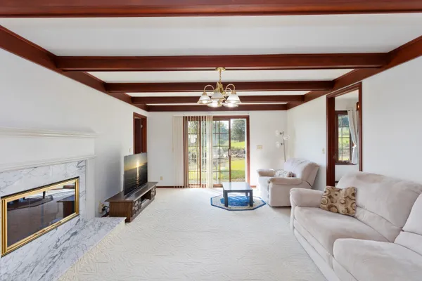 a living room with furniture a fireplace and a chandelier