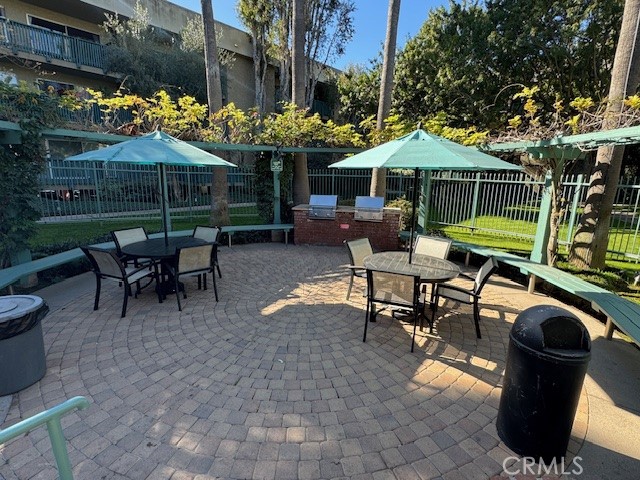 564 North Bellflower Boulevard, Unit 203 Long Beach, CA 90814 - Photo 13 of 20 a view of a patio with a table and chairs under an umbrella