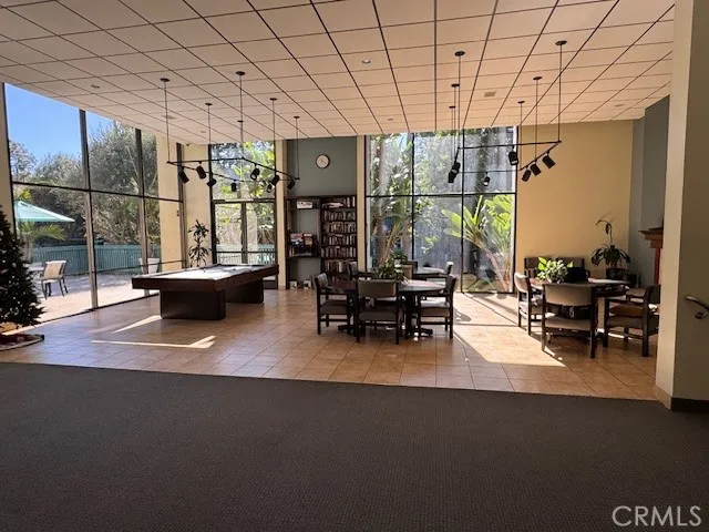 a living room with furniture a flat screen tv and a floor to ceiling window