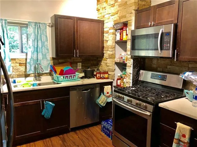 a kitchen with stainless steel appliances a stove and a microwave