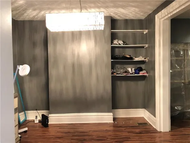 a view of a closet area with wooden floor