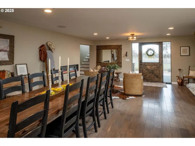 a kitchen with stainless steel appliances kitchen island granite countertop a table chairs and a refrigerator