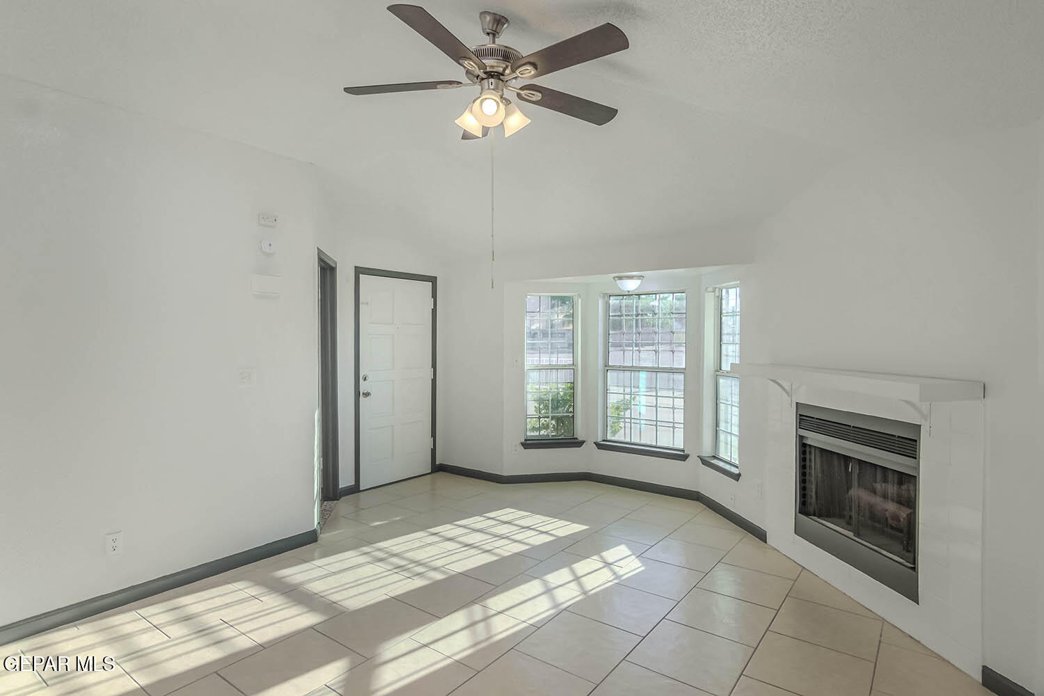 859 Destello Road El Paso, TX 79907 - Photo 5 of 43 a view of a livingroom with a fireplace a ceiling fan and windows
