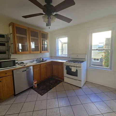 a kitchen with granite countertop a stove top oven cabinets and a counter top space