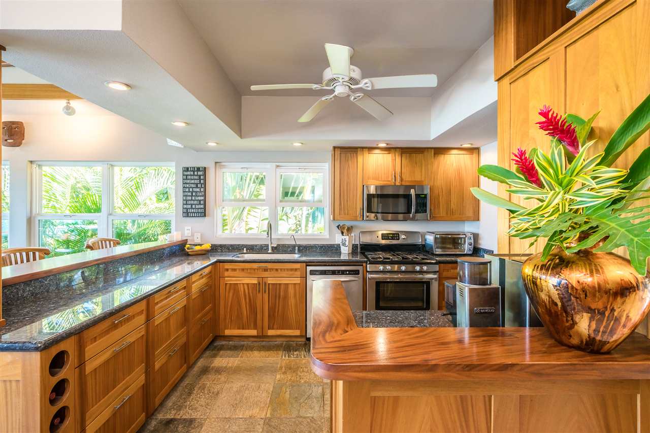 602 Stable Road Paia, HI 96779 - Photo 18 of 30 a kitchen with stainless steel appliances granite countertop a stove a sink and a microwave