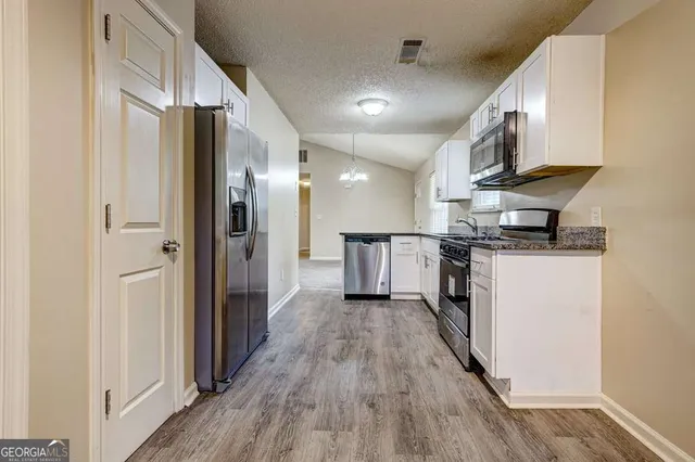 a view of a refrigerator in kitchen and wooden floor