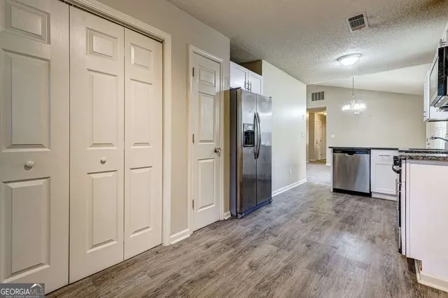 a bathroom with a glass shower door and a walk in closet