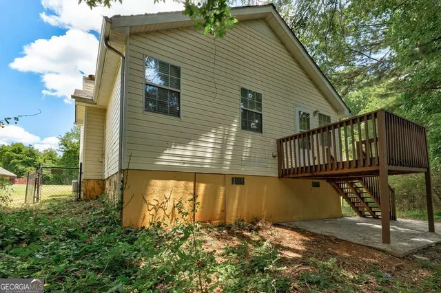 an empty room with chandelier fan and windows