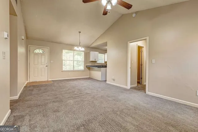 an empty room with windows and fireplace