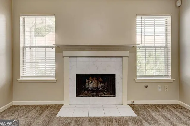 an empty room with chandelier fan and windows