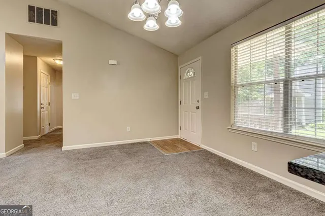 an empty room with windows and a fireplace