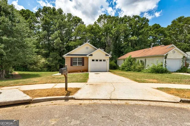 a white house that has a tree in front of it