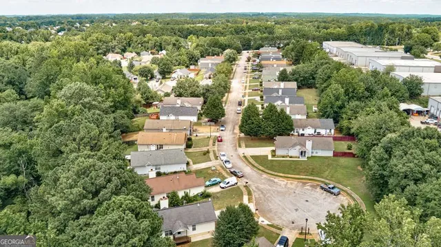 an aerial view of residential houses with outdoor space and trees