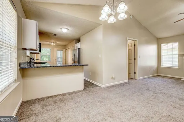 a kitchen with granite countertop a sink stove and refrigerator