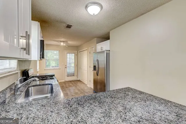 a kitchen with granite countertop a stove and a sink