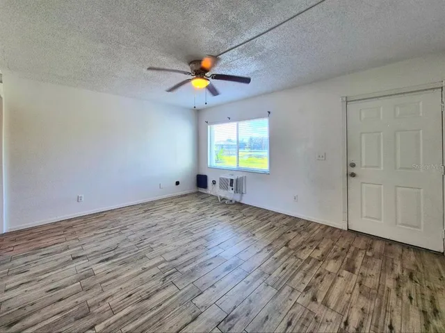 an empty room with window and ceiling fan