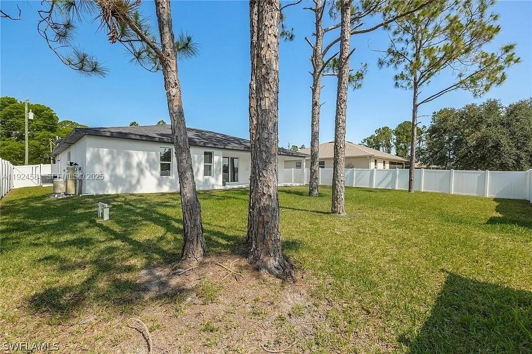830 Angelo Avenue Lehigh Acres, FL 33971 - Photo 12 of 29 a view of a house with backyard and a tree
