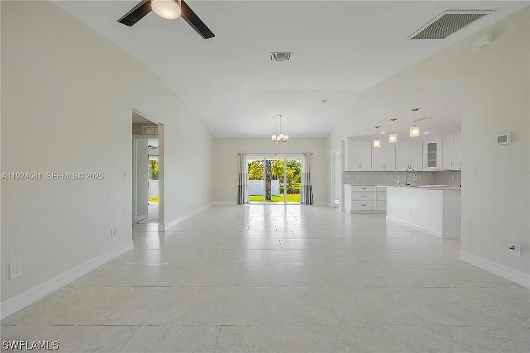 830 Angelo Avenue Lehigh Acres, FL 33971 - Photo 13 of 29 a view of an empty room with window and kitchen view