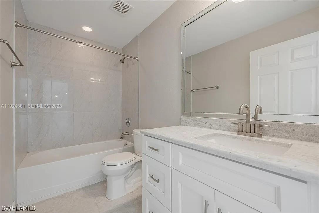 830 Angelo Avenue Lehigh Acres, FL 33971 - Photo 22 of 29 a bathroom with a granite countertop sink a toilet and shower