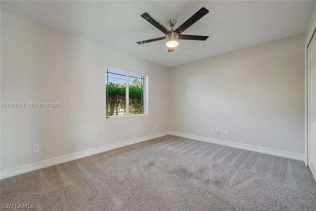 830 Angelo Avenue Lehigh Acres, FL 33971 - Photo 23 of 29 an empty room with a window and a fan