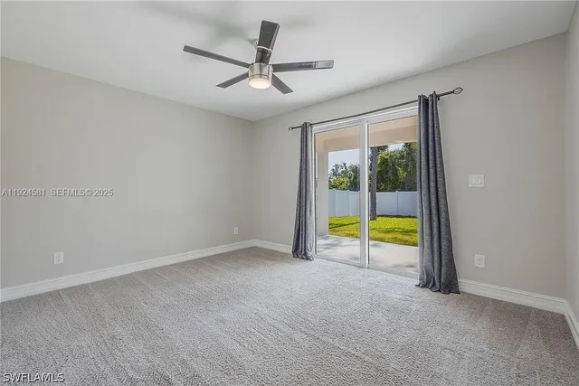 an empty room with a ceiling fan and a window