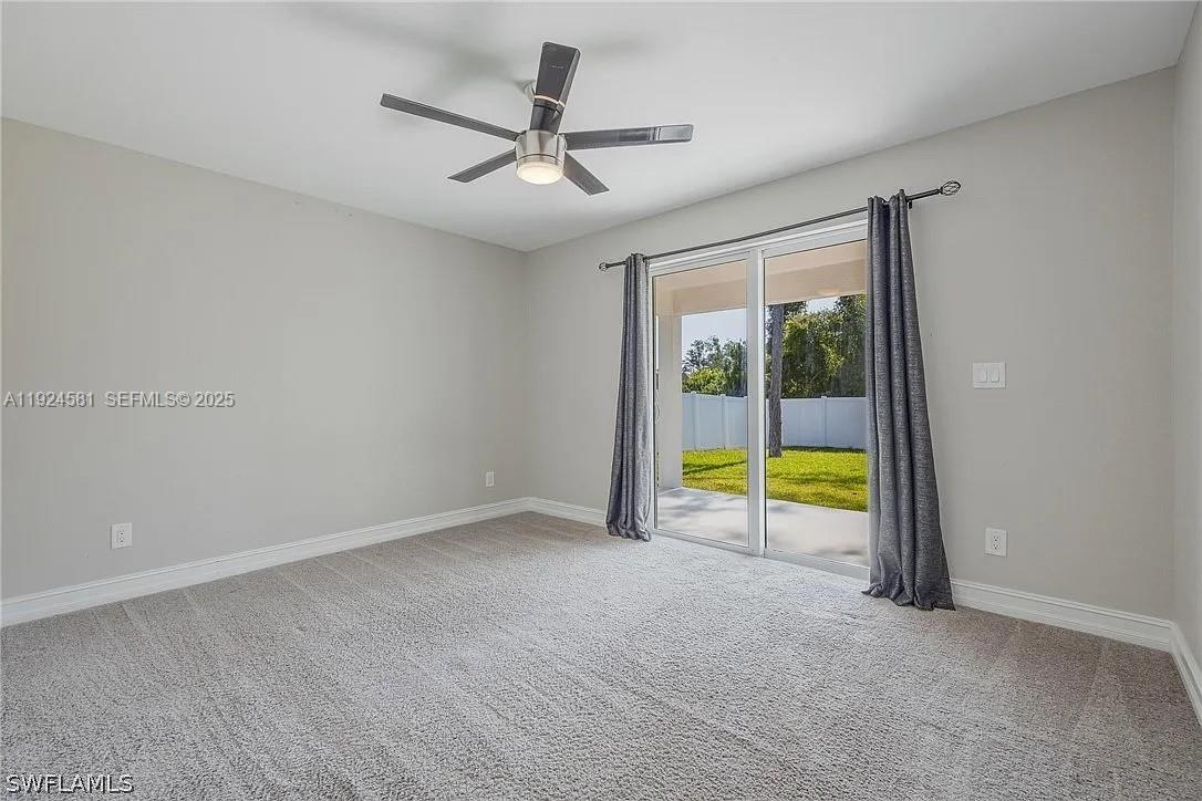 830 Angelo Avenue Lehigh Acres, FL 33971 - Photo 24 of 29 an empty room with a ceiling fan and a window