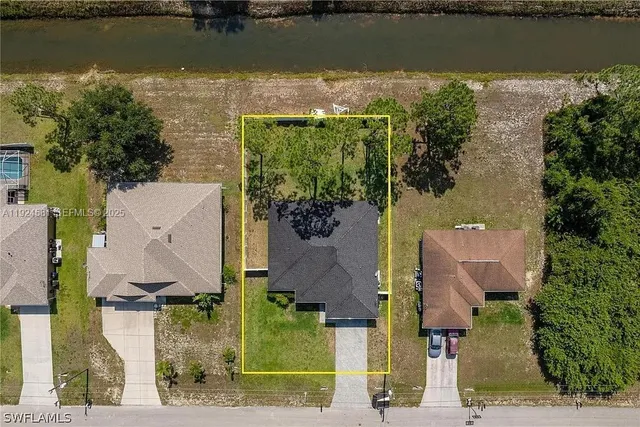 an aerial view of a house with a yard and lake view