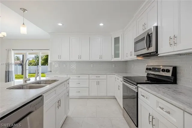 a kitchen with stainless steel appliances granite countertop a sink and a stove