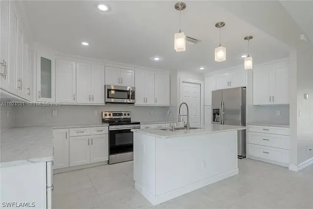 a kitchen with stainless steel appliances granite countertop a sink and a stove
