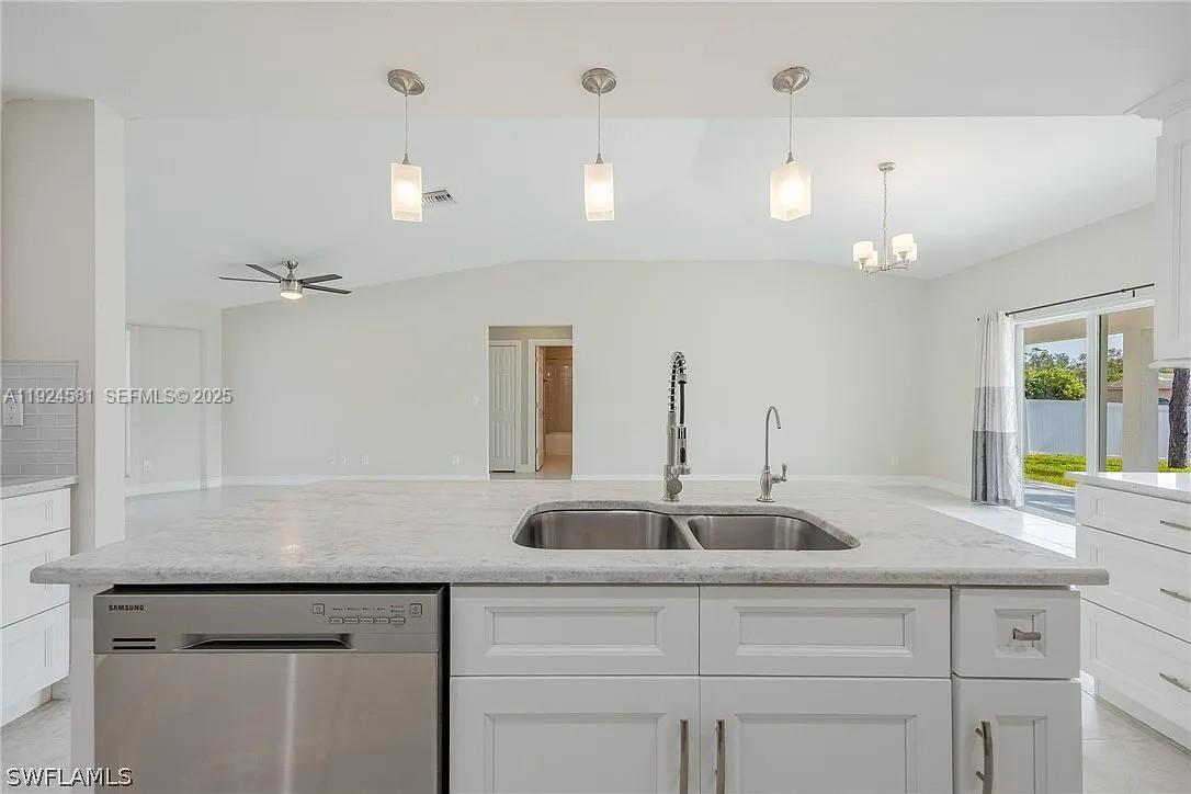 830 Angelo Avenue Lehigh Acres, FL 33971 - Photo 6 of 29 a sink with a granite counter top and chandelier