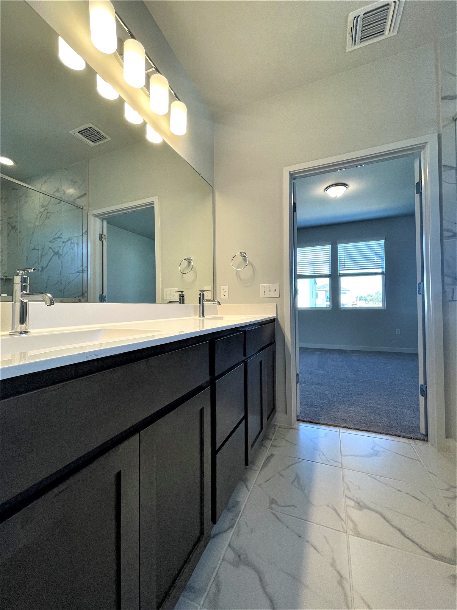 15110 Forum Avenue Pflugerville, TX 78660 - Photo 19 of 29 a bathroom with a double vanity sink a mirror and a bathtub